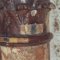 A detail of the surviving capital with a probe showing layers of multiple overpaints
