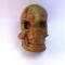 Jedan od pronađenih grobnih priloga – koštana aplika u obliku lubanje čiji su nos i usta prekriveni tkaninom. Snimka: J. Višnjić, 2019.